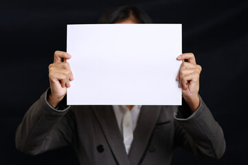 Attractive professional female hands standing and showing blank sheet of paper for advertising on black background isolated