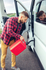Man refueling his camper van with a jerrycan