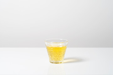 白背景の中のグラスに注がれたお茶