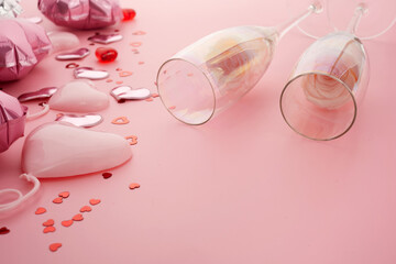 Valentines day pink background with two champagne glasses, hearts and roses.