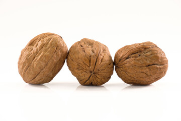 Drei Walnüsse liegen nebeneinander isoliert auf einem weißen Hintergrund