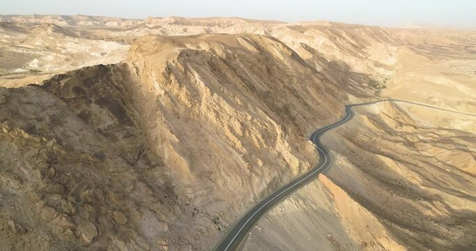 Aerial view of a winding road on a mountain side in the desert at sunrise, Paran rive, Negev, Israel.