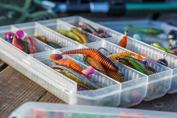 Fishing tackles and fishing baits in box .Classic Colored Fishing Lure , Beautiful Background digital image.Fishing on the lake at sunset.