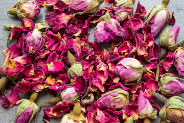 aromatic pink rose flowers for drying lie on a dark wooden table. close-up, top view.