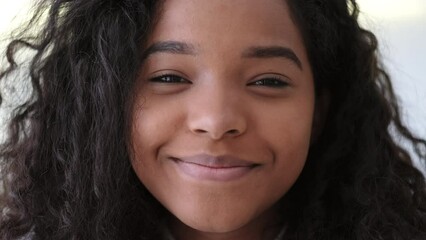 Portrait beautiful African American black girl at modern home Smiling young woman with curly hair looking at camera.