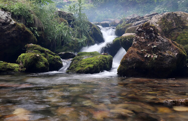 waterfall flowing through mossy rocks