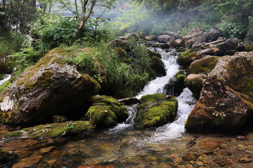 waterfall flowing through mossy rocks