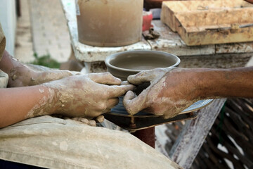 The master teaches pottery. The hands of a potter and a child. Education concept.