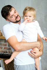 Fototapeta premium Father's Day. The father holds his little child in his arms and smiles. vertical photo. High quality photo