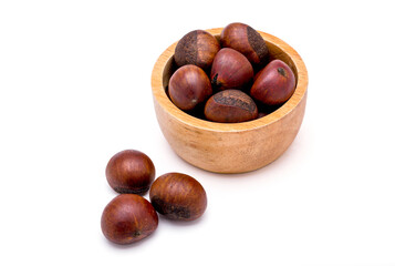 Group of roasted chestnuts on a wooden bowl and in front off bowl isolated on a white background.