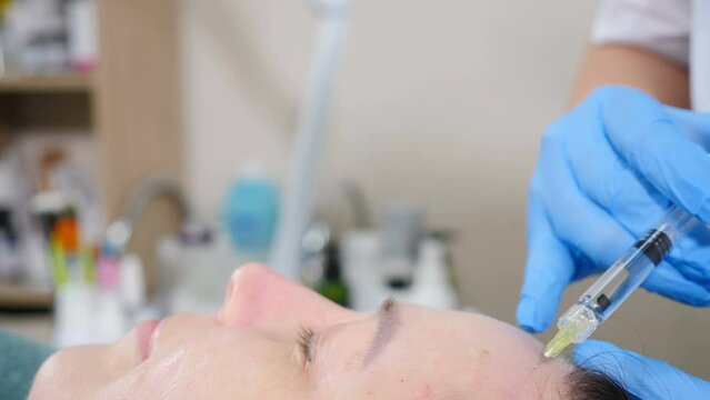 Cosmetic treatment. Cosmetologist makes skin beauty prick for middle-aged woman with short needle. Face lifting procedure. Biorevitalization and mesotherapy. active components into female face for