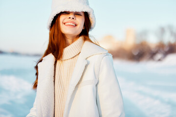 beautiful woman in a white coat in a hat winter landscape walk nature