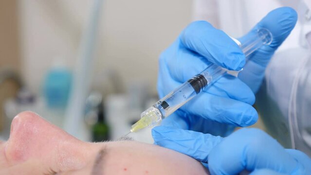 Cosmetologist makes skin beauty prick for middle-aged woman with short needle. Face lifting procedure. Biorevitalization and mesotherapy. active components into female face for tightening and lifting