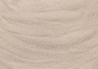 Fototapeta na wymiar Abstract sand texture close up, summer concept. Wavy beige sand, top view. Sandy beach background.
