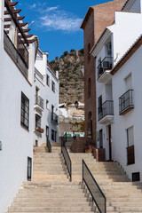 Fototapeta na wymiar Streets of Frigiliana village. Beautiful white houses and small streets. Typically Andalusian town. Touristic travel destination on Costa del Sol. Vertical photography. 