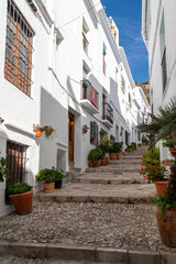 Streets of Frigiliana village. Beautiful white houses and small streets. Typically Andalusian town. Touristic travel destination on Costa del Sol. Vertical photography.   