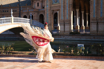 Flamenco dancer, woman, brunette and beautiful typical spanish dancer is dancing with a red manila...