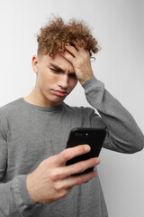 handsome young man looking at the phone fashion light background