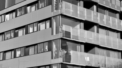 Obraz premium Modern luxury residential flat. Modern apartment building on a sunny day. White apartment building with a blue sky. Facade of a modern apartment building. Black and white.