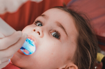 Ultraviolet light in dentistry, the dentist holds a device with ultraviolet light to quickly seal...