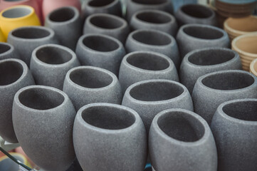 Ceramic products for hygiene products or food. Containers, bowls and vases made of stone are on a shelf in the workshop