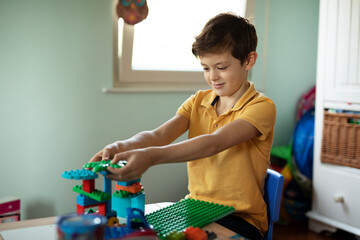 Adorable boy playing with toys at home. Little child playing with lots of toys indoor.