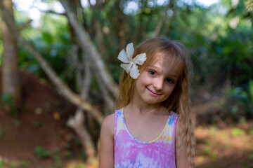 girl in a beautiful pink dress with a white mallow flower in her hair