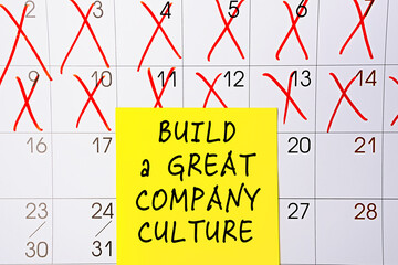 The phrase - Build a Great Company Culture - on a yellow sticky note posted on a calendar or...