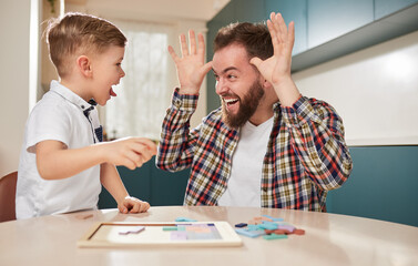 Fototapeta premium Father and son making funny faces at home