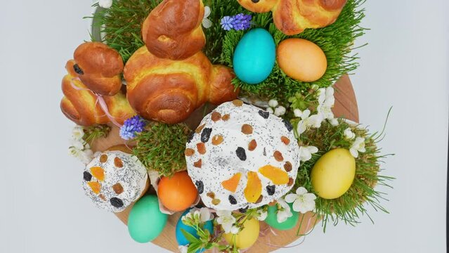 Festively decorated easter bunnies, eggs, easter, wheat sprouts on a rotating wooden surface, top view