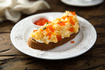 Scrambled eggs toast with cream cheese and caviar