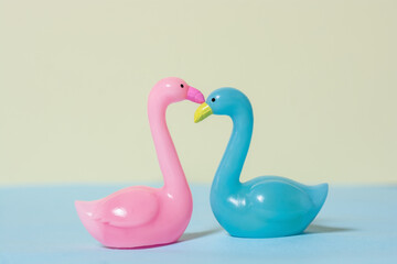 Pink and blue swans on colored background