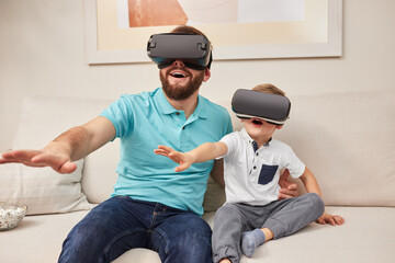Father and son in VR goggles experiencing cyberspace