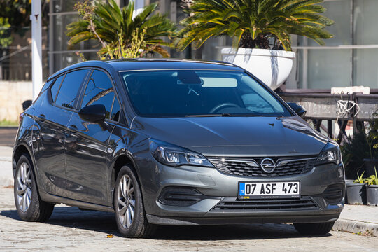 Side, Turkey -January 23, 2022: gray Opel Astra K  is parked  on the street on a warm  day against the backdrop of a buildung, trees, shops