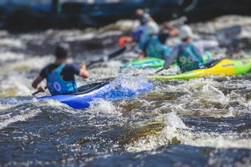 Foto op Canvas Kayak slalom canoe race in white water rapid river, process of kayaking competition with multiple colorful canoe kayak boat paddling, process of canoeing with big water splash © tsuguliev