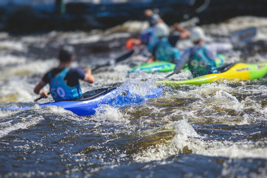 Kayak slalom canoe race in white water rapid river, process of kayaking competition with multiple colorful canoe kayak boat paddling, process of canoeing with big water splash