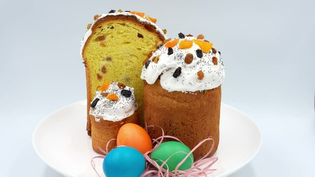 Homemade Easter and Easter eggs on a white plate slowly rotate on a white background, front view
