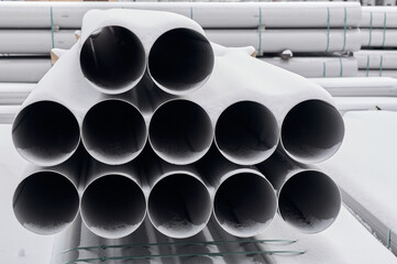 Stainless steel pipes are stacked, these pipes are for the food industry, the pipes are covered...