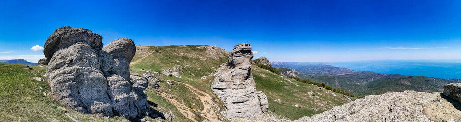 Ancient limestone high mountains of rounded shape in the air haze. The Valley of Ghosts. Demerji. Crimea