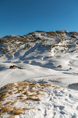 Appennino innevato con rifugio nella valle