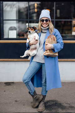Beautiful blonde woman, posing for pictures with her dog and a loaf of bread.