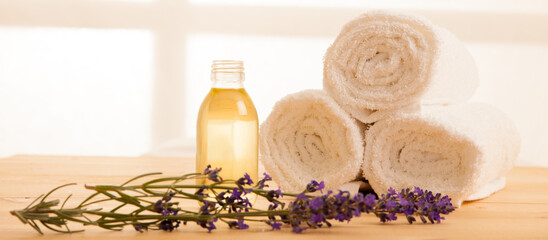 Towels lavender and masage oil on a table in spa salon - 484375103