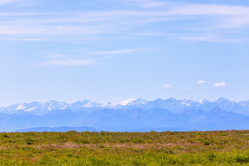Alpine meadow on the plateau of Seiser Alm and a view of Dolomites mountain range with snow...