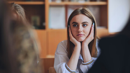 Cute schoolgirl at her desk at school.