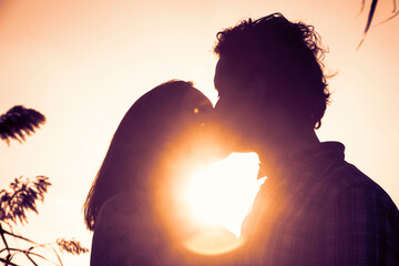 Hombre y mujer besándose en la puesta de sol. Romanticismo. - obrazy, fototapety, plakaty