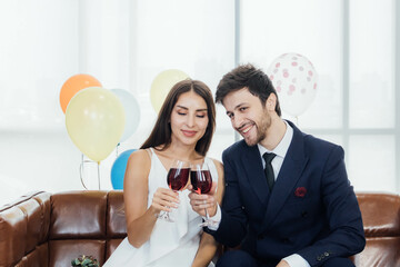 Young couple celebrating new year together, drinking wine together.