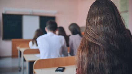 Pupils of the 11th grade in the class at the desks during the lesson. Russian school.