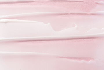 Texture of cream on a pink background.