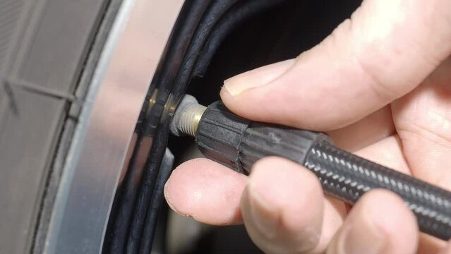 Inflating tire. Filling air in the tires before travel. man hand open valve cap and inflate car tyre before driving. checking car wheel air pressure using gauge. Automotive vehicle. Car wheel air fix.