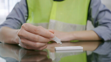 Close-up hand of engineering woman drop liquid rapid antigen self-test. Coronavirus, COVID-19.